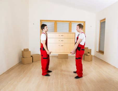 Professional movers handling household furniture and boxes in a Paddington flat